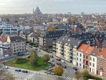 Een uitzicht op Jette, Koekelberg en Ganshoren, met onderaan in beeld een perceel waarop een bosje geplant zal worden. Aan de horizon is de Basiliek van Koekelberg te zien