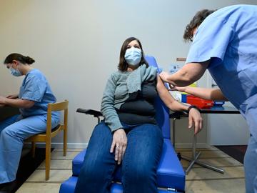 Een vrouw krijgt een corona-vaccin toegediend in het  vaccinatiecentrum Pacheco in Brussel-Stad