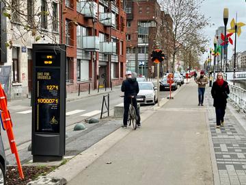 Een foto van het fietspad langs de Koolmijnenkaai in Molenbeek, met in beeld meer dan een miljoen fietsers geteld op de fietstelpaal