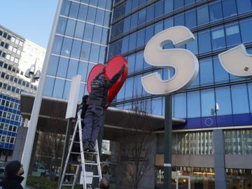 Een medewerker van de gemeente Sint-Joost-ten-Node hangt het hartje weer tussen de letters op het Madouplein