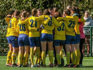 De vrouwen van RUSG Girls staan samen in een kring