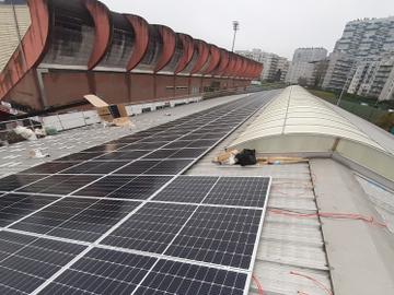 Zonnepanelen op het dak van de hal van Tennis Club Le Chalet, links in beeld het Edmond Machtensstadion