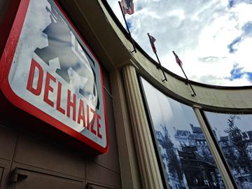 Supermarkt Delhaize in de de Henninstraat in Elsene: een foto van omstreeks 1900 herinnert aan de beginjaren van Delhaize & Frères, toen er nog met paard en kar aan huis geleverd werd.