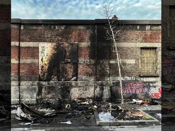 Schade aan een muur in de Pottengoedwijk in Kuregem nadat hier afval in brand werd gestoken. Geen alleenstaand geval, volgens buurtbewoners