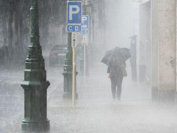 onweer regen paraplu windstoten rukwinden beaufort slecht weer stortbui parkeerplaats verkeersbord