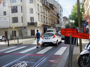 Een voetganger steekt de Haachtsesteenweg over op een zebrapad in Schaarbeek