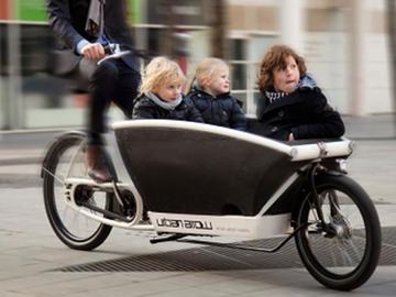 Drie kinderen me eop een Urban Arrow cargofiets