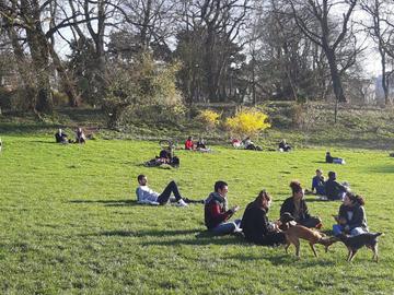 Groepjes mensen in de lentezon in het Park van Vorst