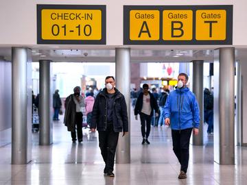 Passagiers met mondmaskers op Brussels Airport, als bescherming tegen het coronavirus (covid-19)