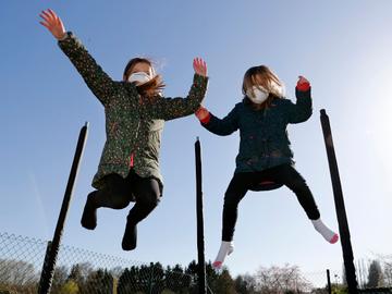 Brusselse kinderen spelen op een trampoline met mondmaskers om infectie met het coronavirus (covid-19) te voorkomen