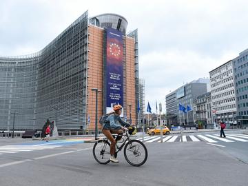 Een fietser aan het Berlaymontgebouw in de Europese wijk. Er is bijna geen verkeer door de lockdownmaatregelen van de overheid om covid-19, de ziekte veroorzaakt door het coronavirus, in te dijken