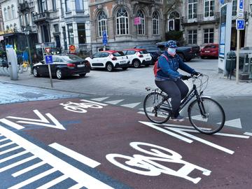 Een fietser in Brussel. Er is bijna geen verkeer door de lockdownmaatregelen van de overheid om covid-19, de ziekte veroorzaakt door het coronavirus, in te dijken.