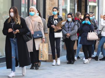Een wachtrij van klanten met mondmasker in de Nieuwstraat