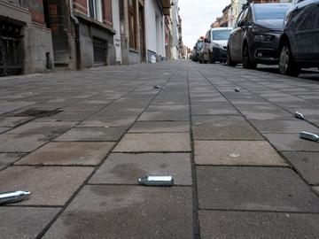 Lachgascapsules op het voetpad in de Edmond Tollenaerestraat in Laken waar in december 2020 een lockdownfeestje werd stilgelegd door de politie