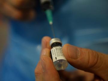 Een verpleger brengt alles in gereedheid voor een injectie met het vaccin tegen Covid-19 van Pfizer/BioNTech in het Brussels rusthuis Notre Dame de Stockel