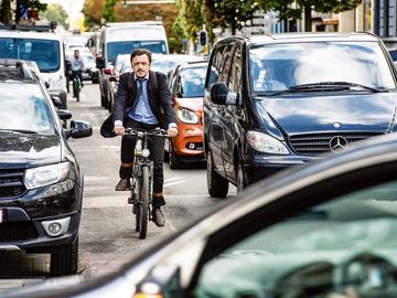 Een fietser deelt het verkeer met auto's
