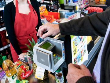 Een klant in een winkel van supermarktketen Carrefour betaalt met zijn maestrokaart