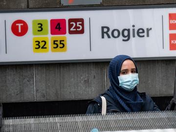 Een vrouw met hoofddoek verlaat metrostation Rogier