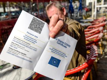 Een man op een Brussels terras toont zijn Covid Safe Ticket (CST) 