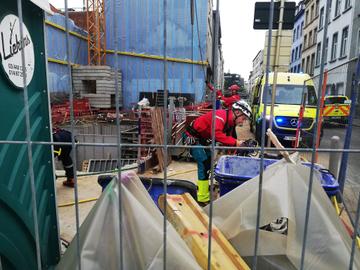 29 april 2022: de brandweer daalt met klimmateriaal af in de bouwput van een werf op de hoek van de Slachthuisstraat en de Slachthuislaan (Kleine Ring)