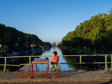 Hittegolf in Brussel, september 2023: Flow, openluchtzwembad aan het kanaal in Anderlecht. Een vrouw geniet van de zon op de Marchantbrug