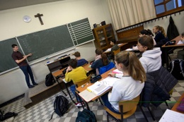 Een leraar voor zijn klas in de middelbare school van het Sint-Jan Berchmanscollege secundair onderwijs leerlingen kruisbeeld katholiek jezuïten