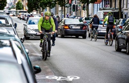 Een fietser deelt het verkeer met auto's