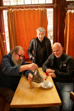 Hombres complicados: Arno, Josse De Pauw en Dominique Deruddere in het door de coronamaatregelen gesloten café Le Coq. Een interview in BRUZZ magazine van 28 april 2021, naar aanleiding van "Charlatan", de documentaire die Dominique Deruddere over Arno ma