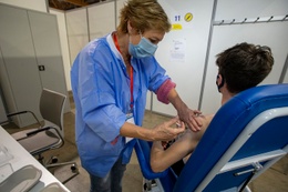 Een jonge man krijgt een coronavaccin toegediend in het vaccinatiecentrum aan de Heizel